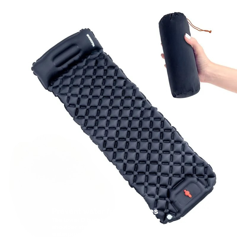 Black inflatable sleeping pad with a hand holding its carrying case on a white background