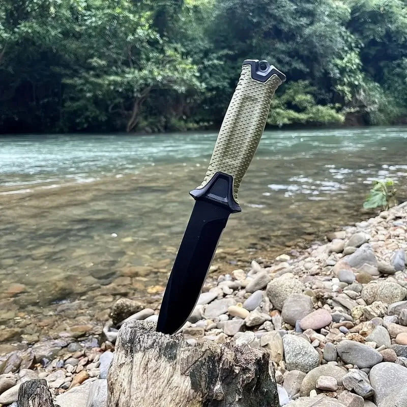 Fixed blade survival knife with textured grip, outdoor camping knife displayed by river for hiking and bushcraft use