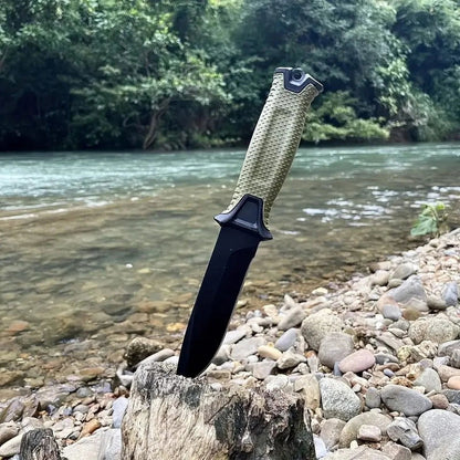 Fixed blade survival knife with textured grip, outdoor camping knife displayed by river for hiking and bushcraft use