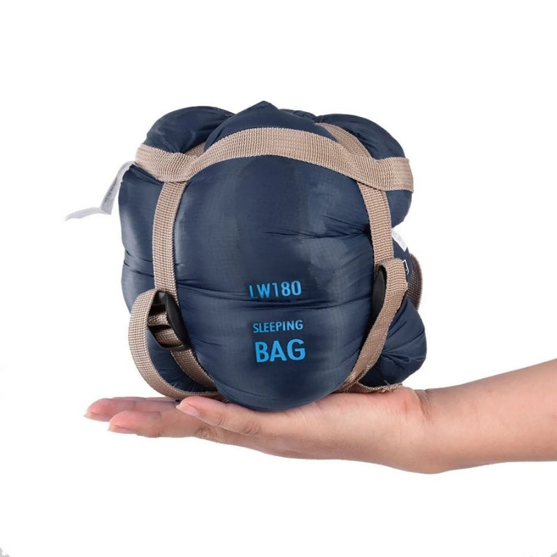 680g ultralight sleeping bag in navy blue compressed, held in one hand