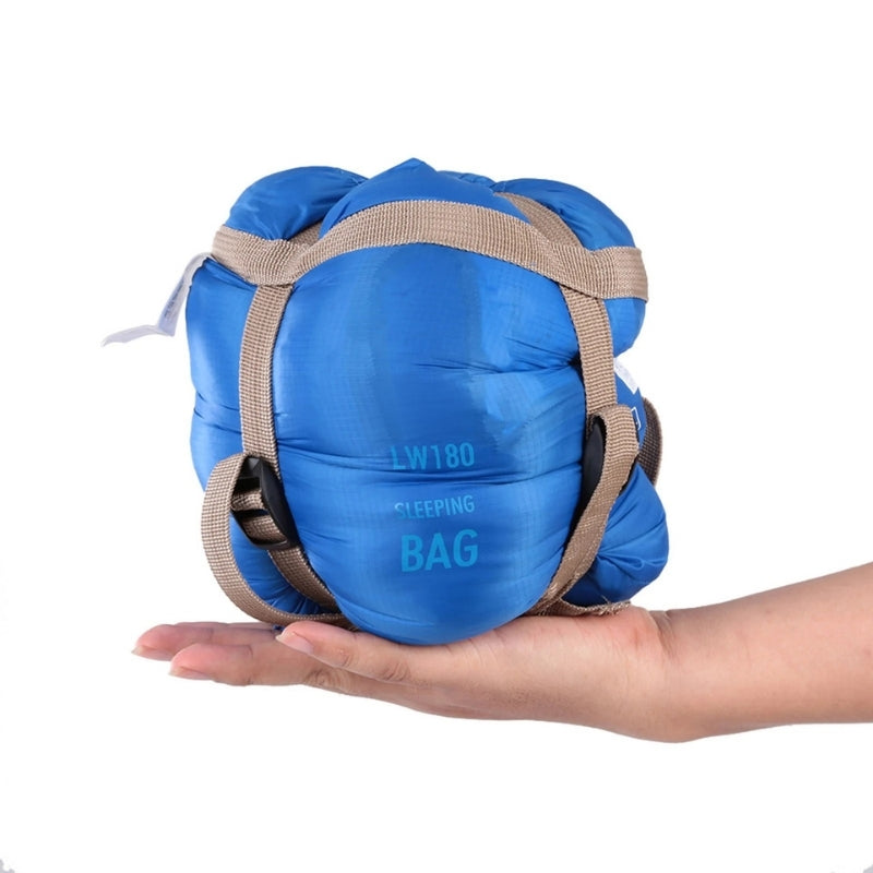 680g ultralight sleeping bag in blue compressed, held in one hand