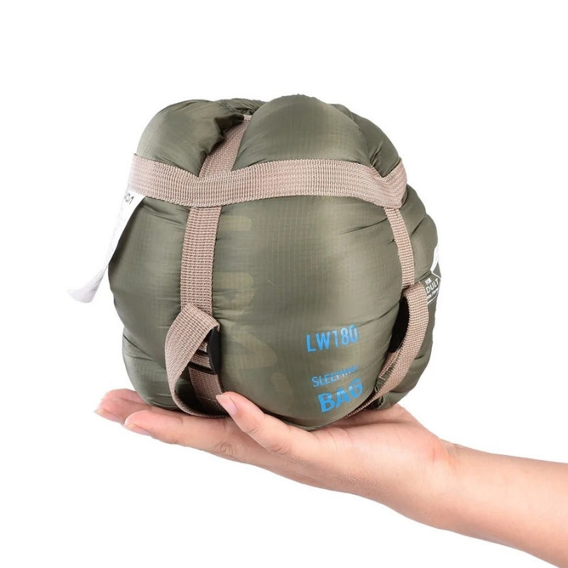 680g ultralight sleeping bag in orange compressed, held in one hand