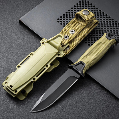 Green camping knife with black blade on a textured surface