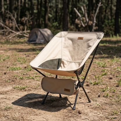 Folding camping chair set up at a campsite in beige — portable lightweight beach and camping chair