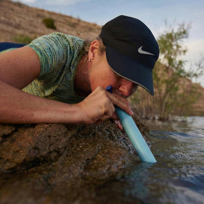 Portable water filter straw for hiking and emergencies, drinking clean water directly from river
