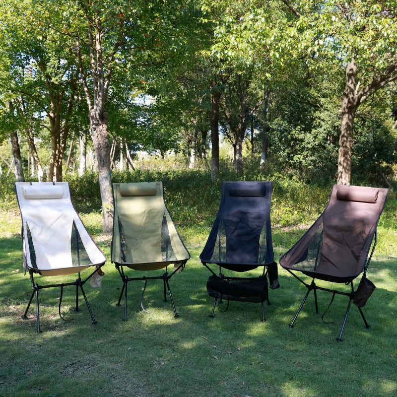 Four high back camping chairs in different colours set up outdoors on grass