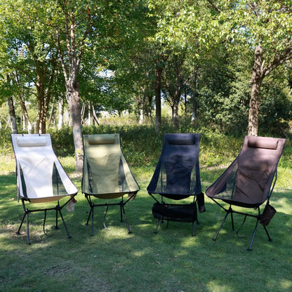 Four high back camping chairs in different colours set up outdoors on grass