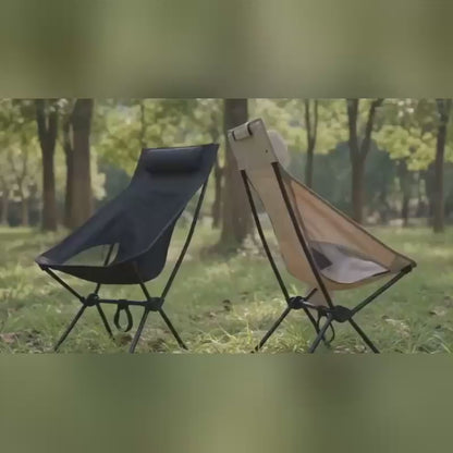 High back camping chair in dark colour set up outdoors in natural light