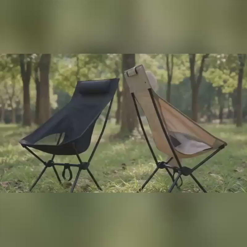 High back camping chair in dark colour set up outdoors in natural light