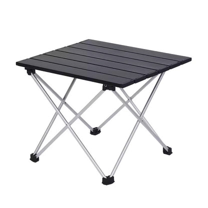 Portable folding camping table with aluminium slatted top and X-frame legs, studio shot