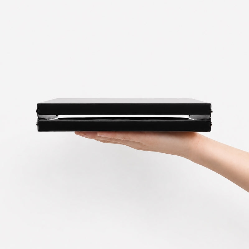 Ultralight folding table folded flat showing 3.5cm thickness held in hand