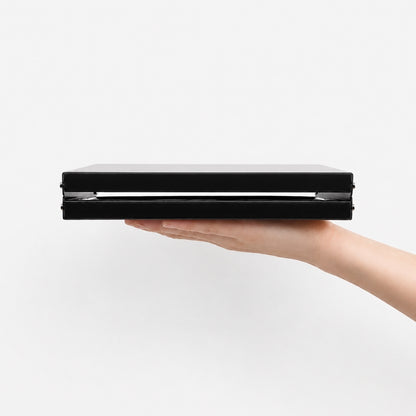 Ultralight folding table folded flat showing 3.5cm thickness held in hand